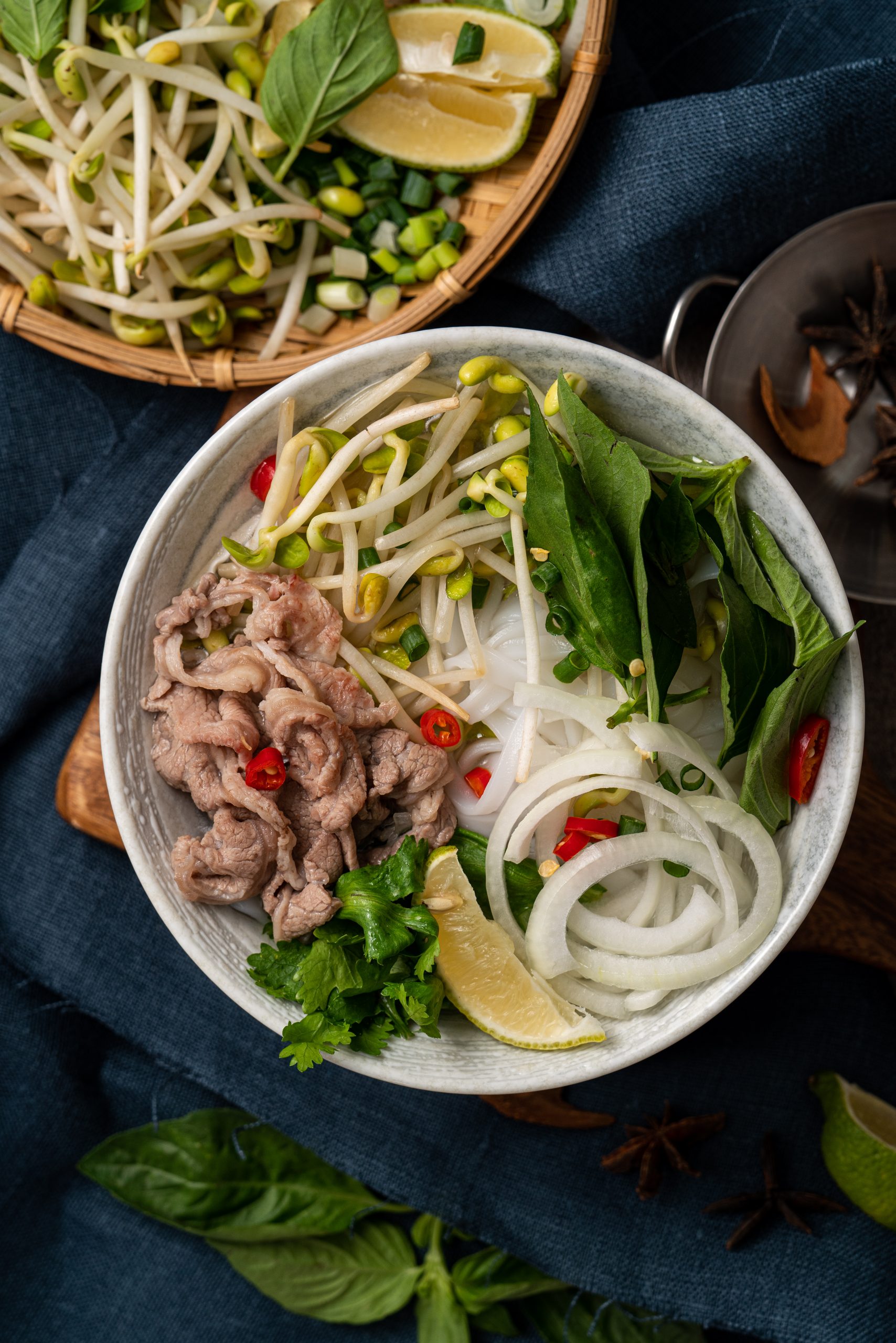 Top view of delicious vietnamese beef noodles pho in a bowl with ingredients with copy space.
